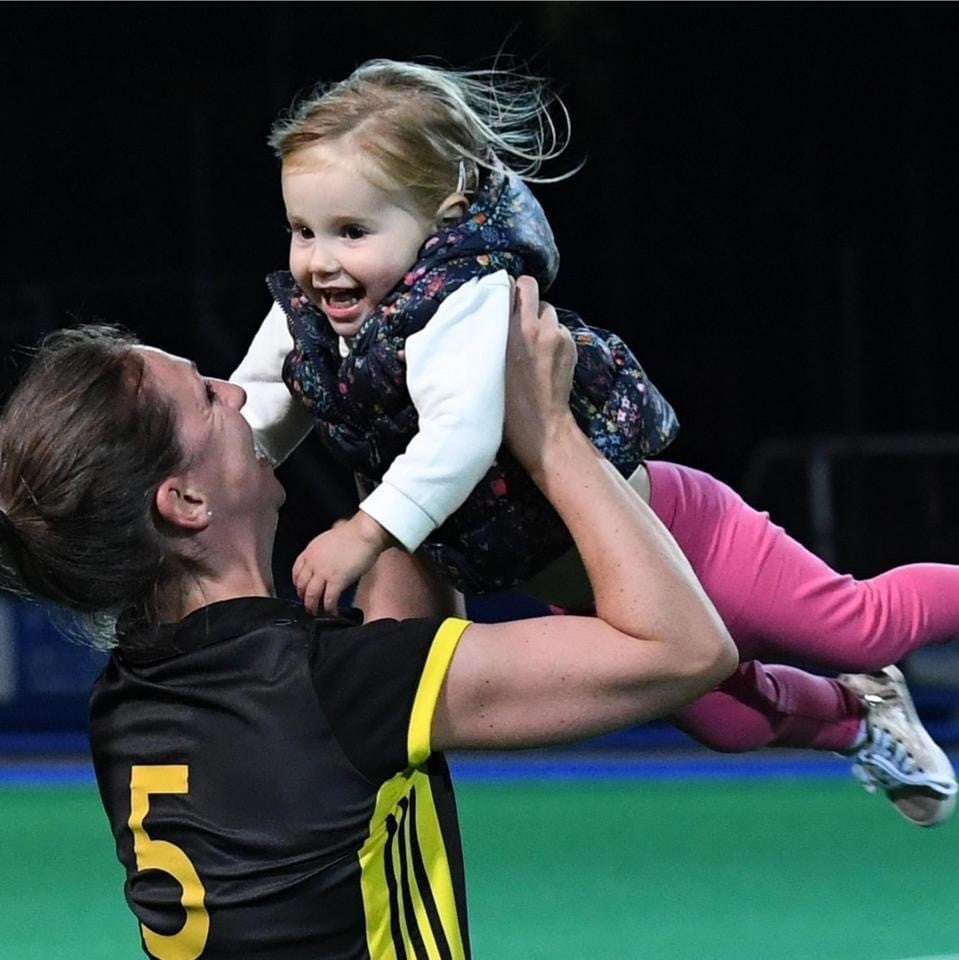 Ella with her mum after a hockey match